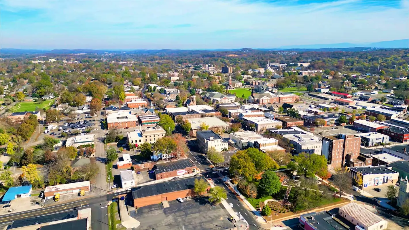 Aerial view of downtown Cleveland, Tennessee in autumn, with brick commercial buildings, tree-lined streets and ridges on the horizon