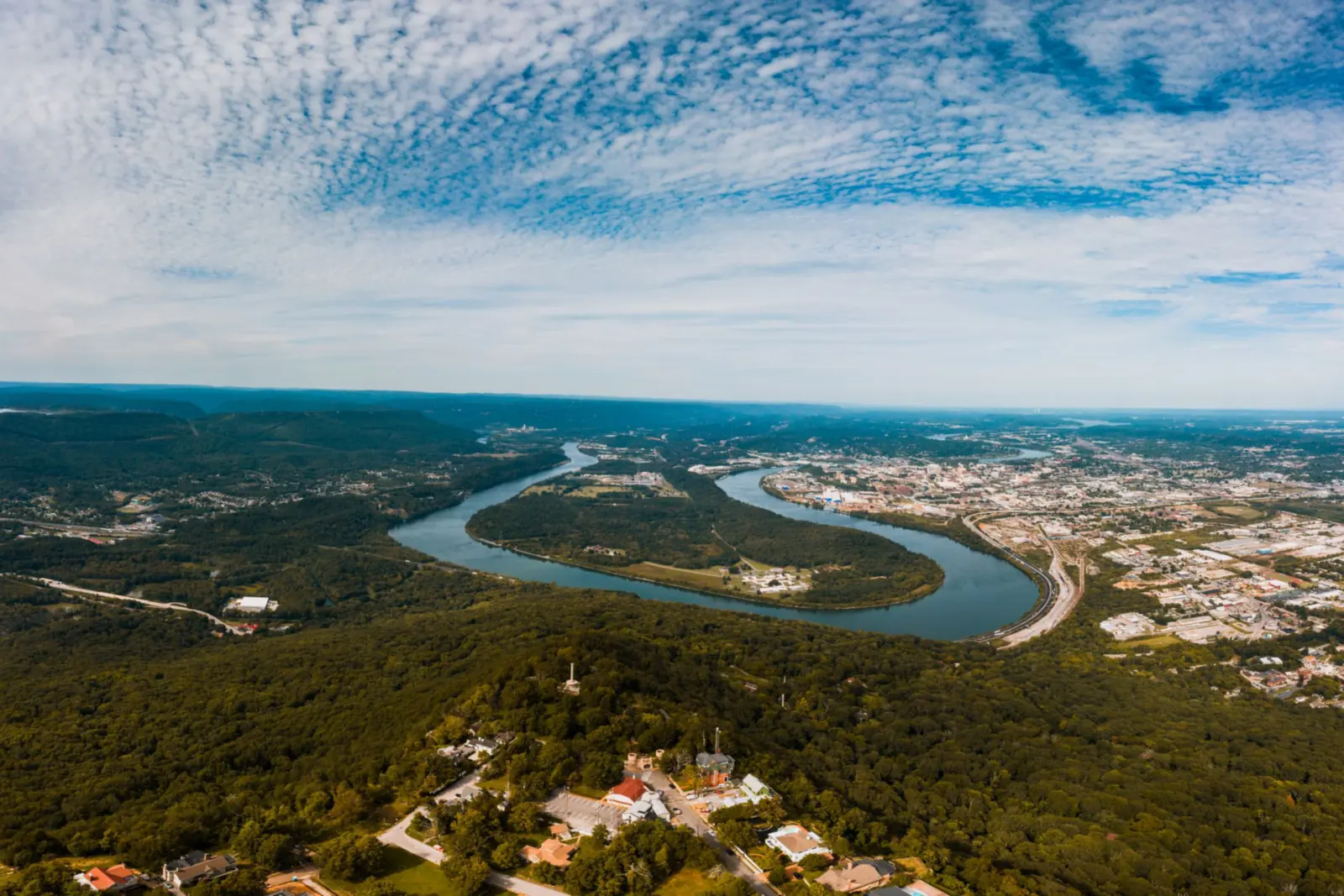 Aerial view from Lookout Mountain over Moccasin Bend, where the Tennessee River loops through green forest beside Chattanooga.